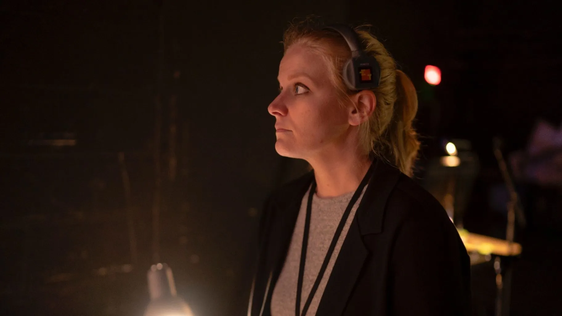 Susan in profile wearing headphones backstage