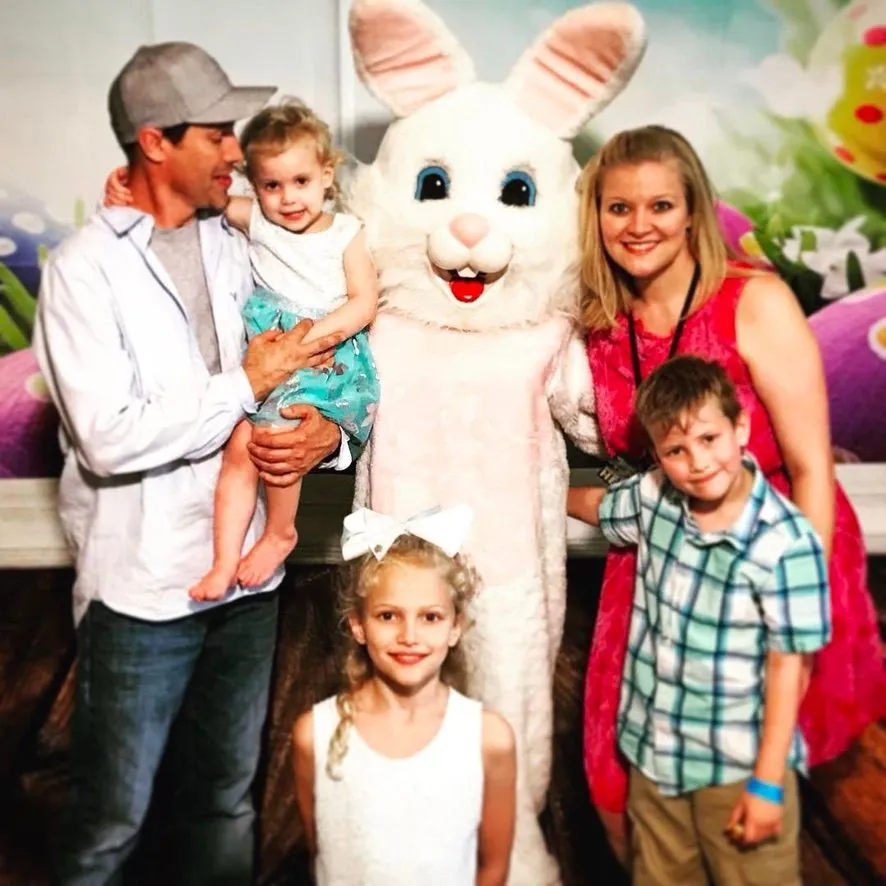 Susan with her husband Jeremy and their children beside an Easter bunny